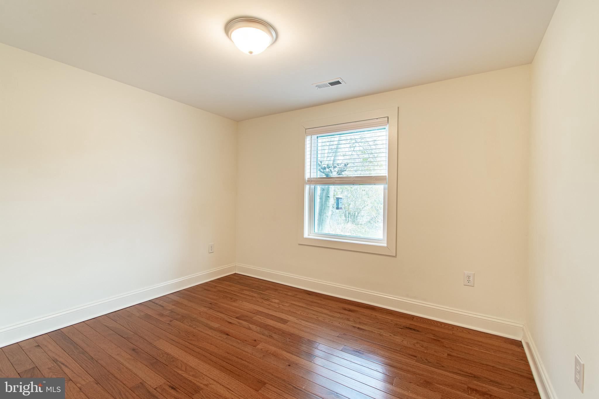 101 Brooks Lane St. Michaels, MD 21663 - Photo 18 of 28 an empty room with wooden floor and windows