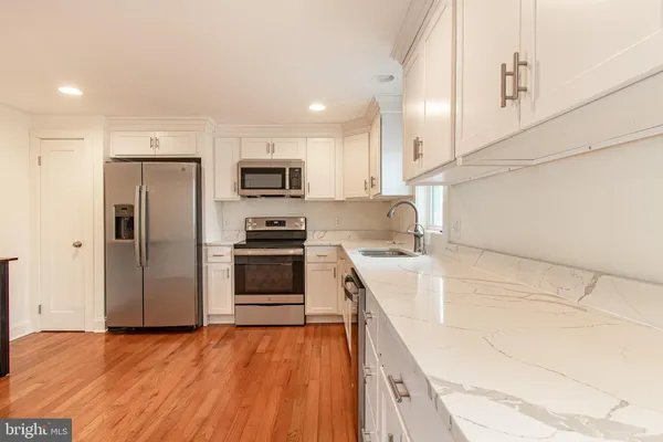a kitchen with stainless steel appliances a refrigerator and a stove top oven