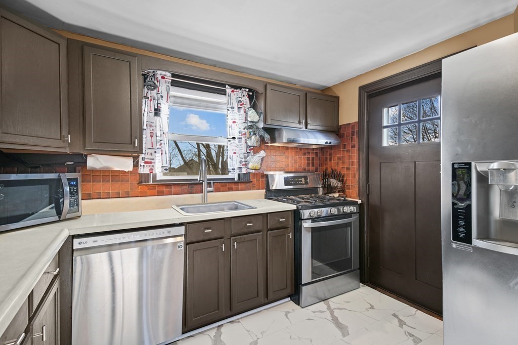 40 Harrison Street Cumberland, RI 02864 - Photo 3 of 37 a kitchen with stainless steel appliances granite countertop a sink stove and refrigerator