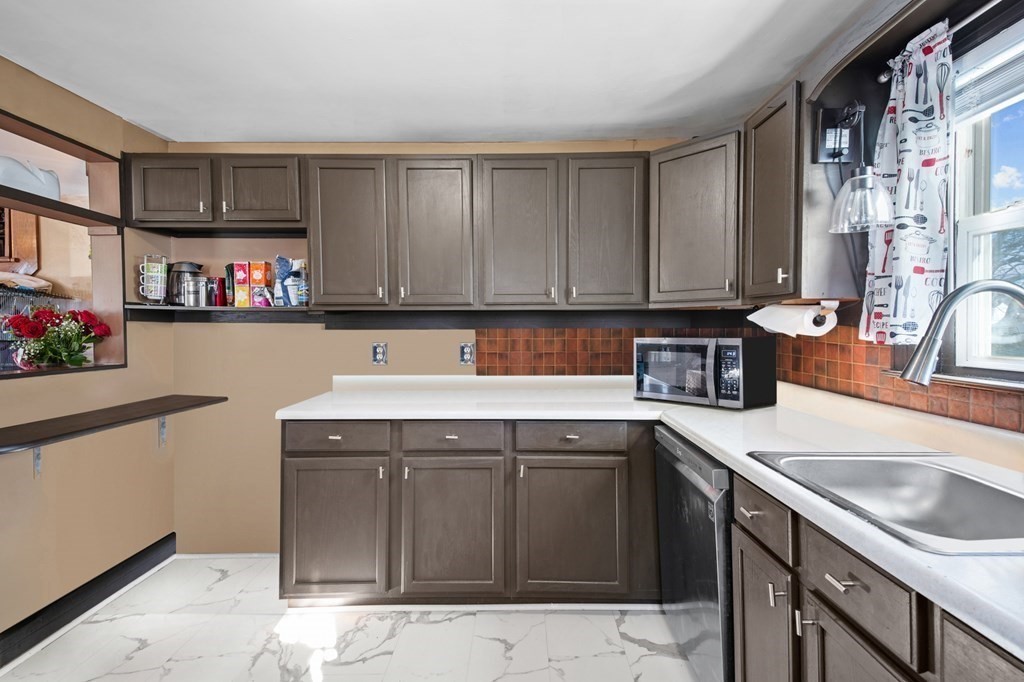 40 Harrison Street Cumberland, RI 02864 - Photo 4 of 37 a kitchen with a sink stove top oven and cabinets