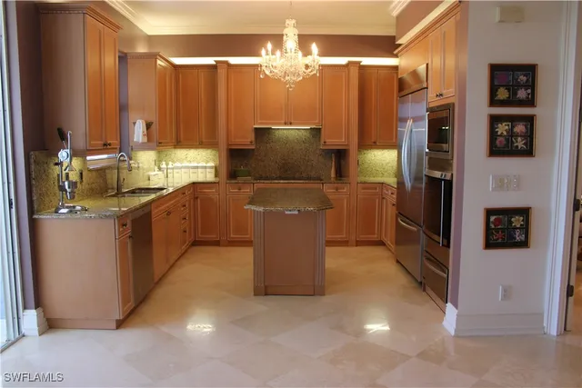 a kitchen with stainless steel appliances granite countertop a refrigerator a stove and a sink