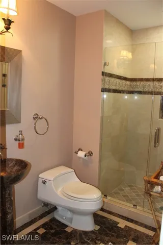 a bathroom with a toilet a sink and shower