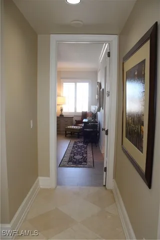 a view of a hallway and a livingroom with furniture