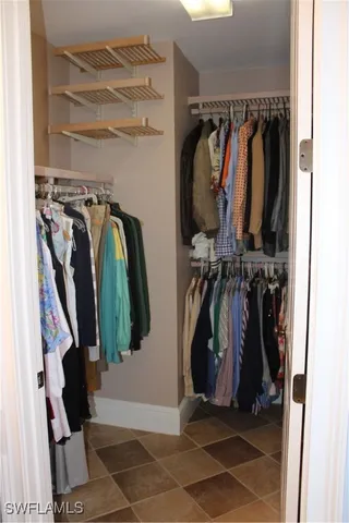 a view of walk in closet with clothes and shoes