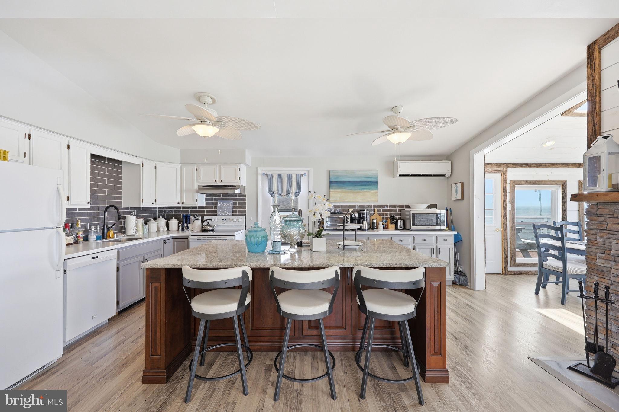 173 Cove Road Newport, NJ 08345 - Photo 11 of 72 a dining room with stainless steel appliances kitchen island granite countertop a dining table chairs and view living room