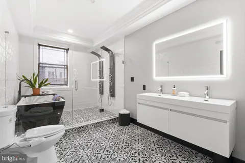 a bathroom with a sink a toilet and shower