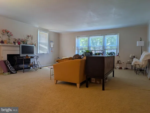 a view of a livingroom with workspace and a window