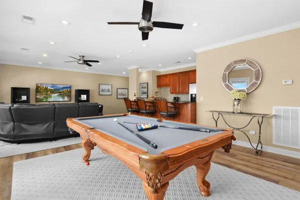 a kitchen with stainless steel appliances granite countertop wooden cabinets a stove a sink a dining table and chairs