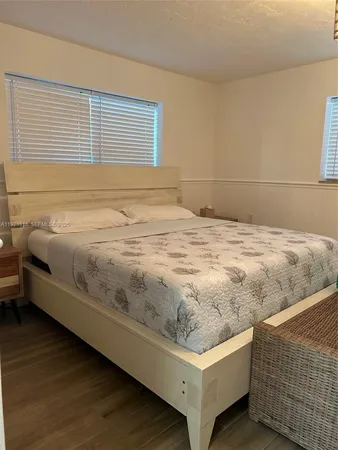 a living room with a flat screen tv a rug and wooden floor