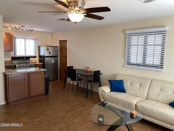 a living room with furniture a ceiling fan and a window