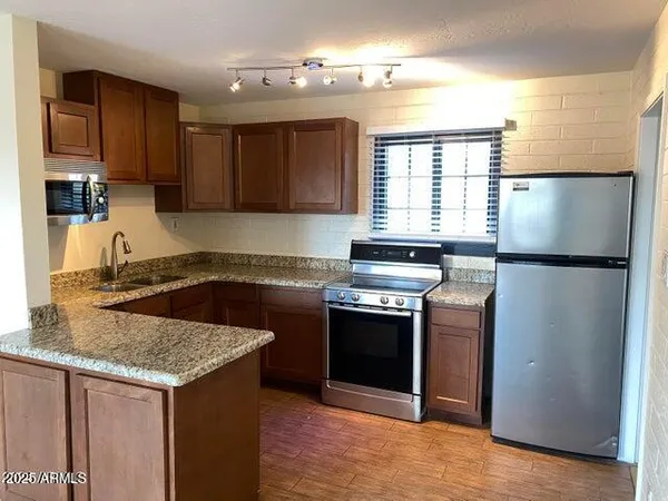 a kitchen with stainless steel appliances granite countertop a stove a refrigerator and a sink
