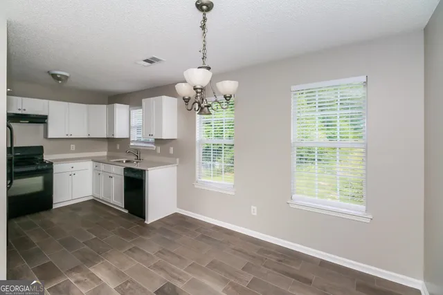 a open kitchen with a refrigerator a stove top oven a sink and dishwasher with wooden floor