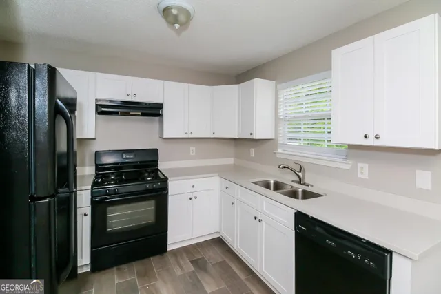 a kitchen with a sink stove and refrigerator