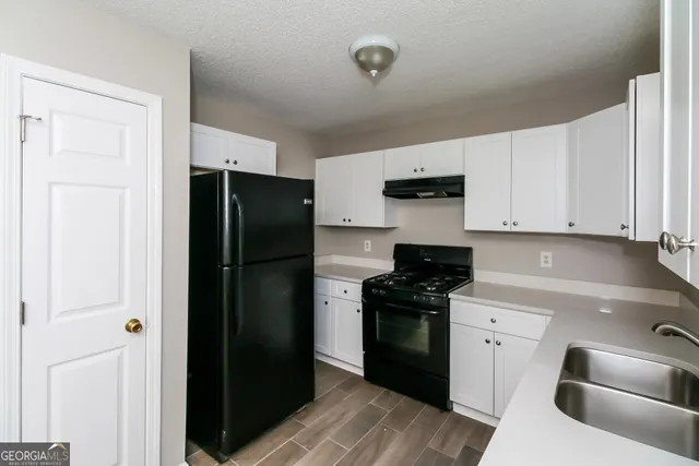 a kitchen with a refrigerator stove and sink