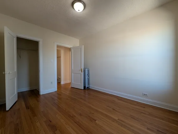 an empty room with wooden floor and closet
