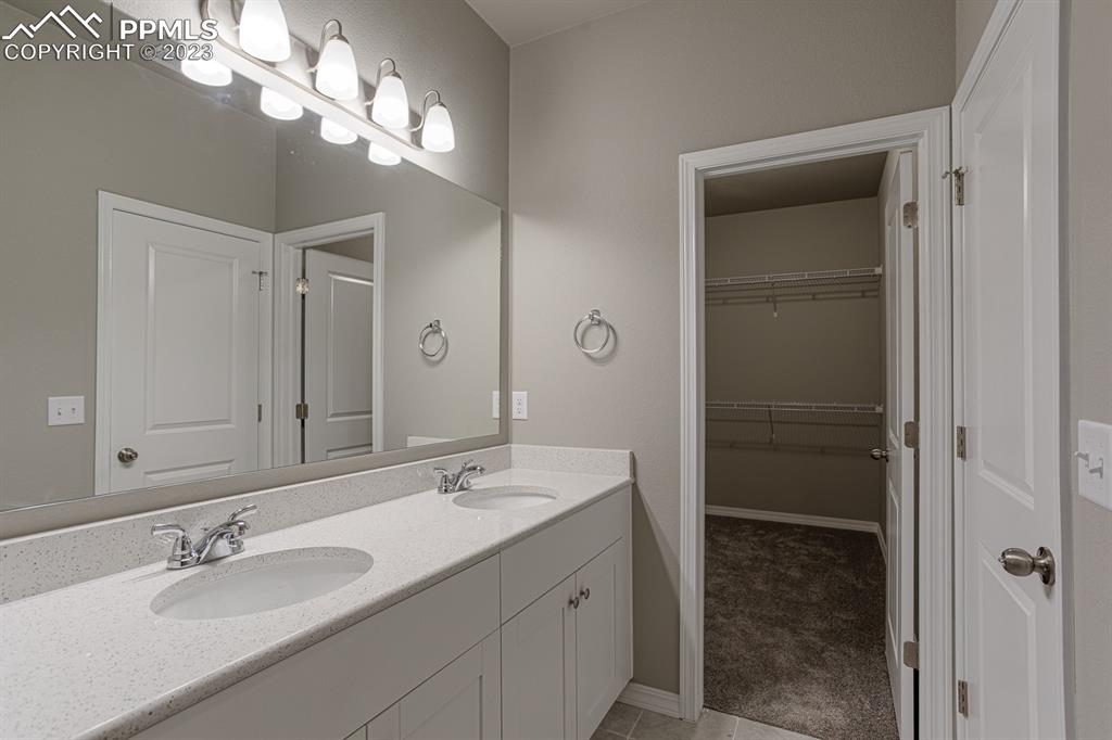4336 Samaritan Loop Colorado Springs, CO 80916 - Photo 12 of 22 a bathroom with a double vanity sink and a mirror