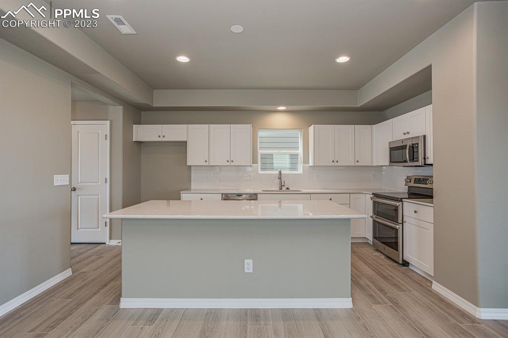 4336 Samaritan Loop Colorado Springs, CO 80916 - Photo 4 of 22 a kitchen with stainless steel appliances a sink stove and refrigerator