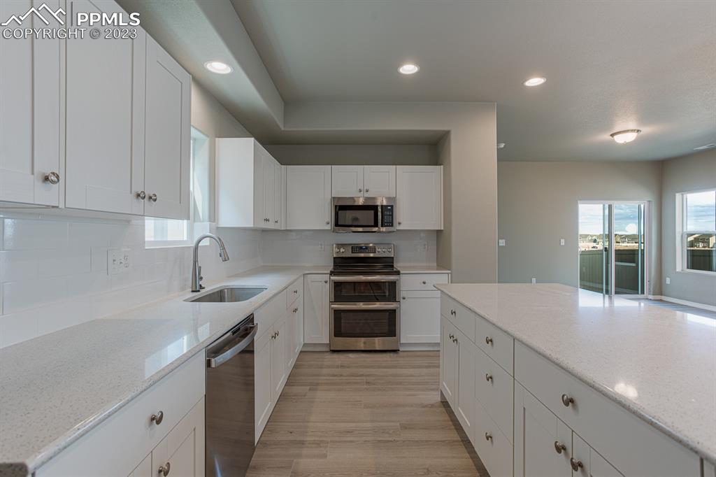 4336 Samaritan Loop Colorado Springs, CO 80916 - Photo 5 of 22 a kitchen with granite countertop a sink and white stainless steel appliances