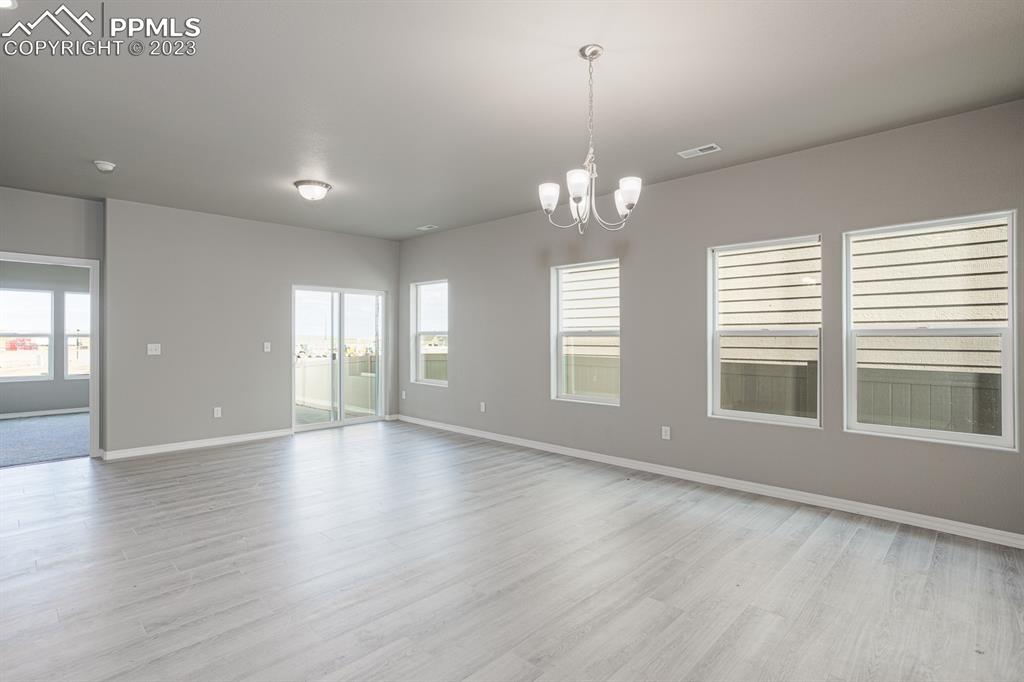 4336 Samaritan Loop Colorado Springs, CO 80916 - Photo 6 of 22 an empty room with wooden floor and windows