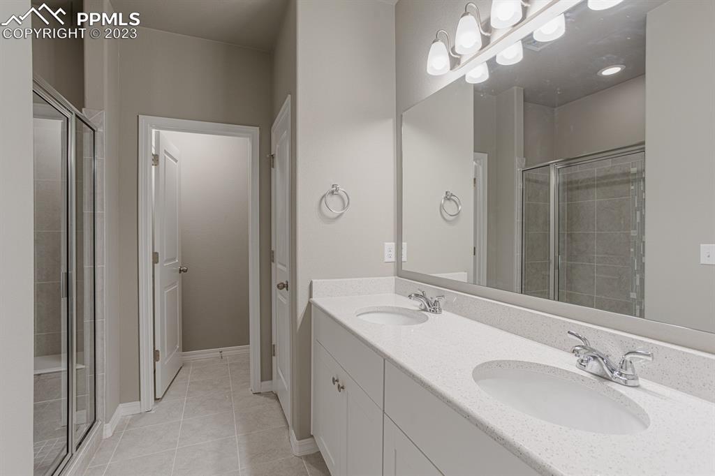 4336 Samaritan Loop Colorado Springs, CO 80916 - Photo 10 of 22 a bathroom with a sink vanity granite and a mirror