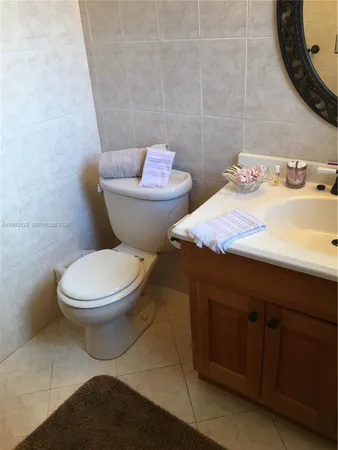 a bathroom with a sink a toilet a mirror and window