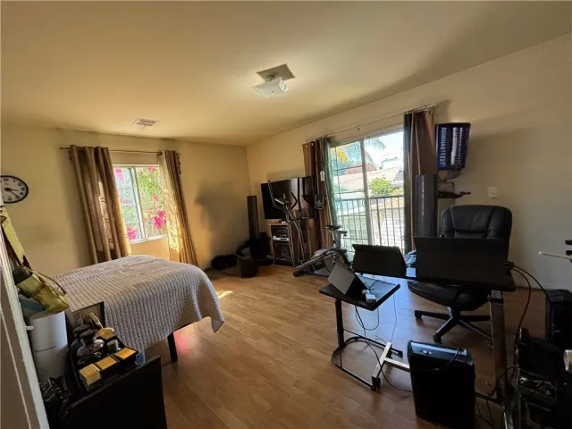 a kitchen with stainless steel appliances kitchen island granite countertop a dining table chairs and a refrigerator