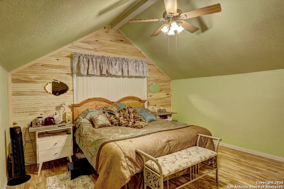 101 North 11th Street Junction, TX 76849 - Photo 12 of 26 a bedroom with a bed and a chandelier
