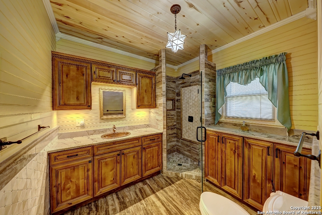 101 North 11th Street Junction, TX 76849 - Photo 20 of 26 a bathroom with a sink a mirror a vanity and a shower