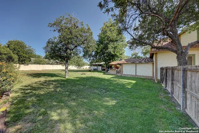 a view of a backyard with large trees