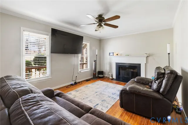 a living room with furniture ceiling fan and a window