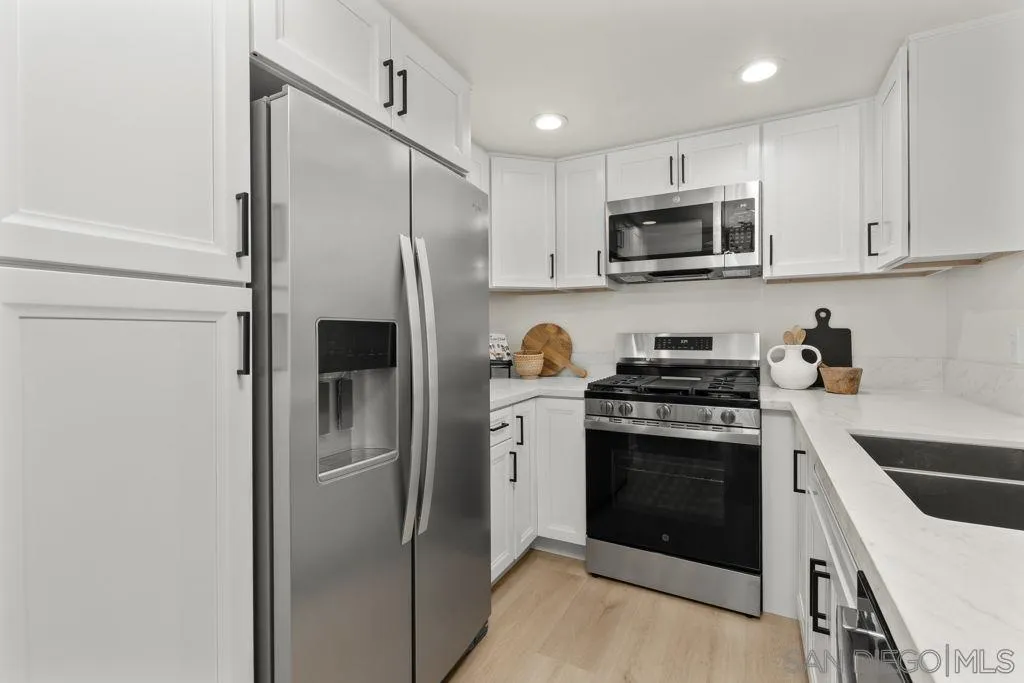 761 Brookstone Road, Unit 102 Chula Vista, CA 91913 - Photo 5 of 34 a kitchen with stainless steel appliances granite countertop a refrigerator stove and sink