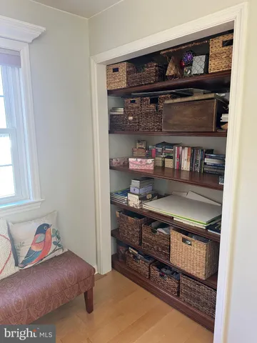 a living room with a wooden floor and shelf