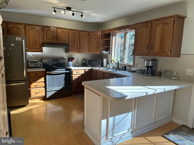 a kitchen with kitchen island granite countertop a sink stove and refrigerator