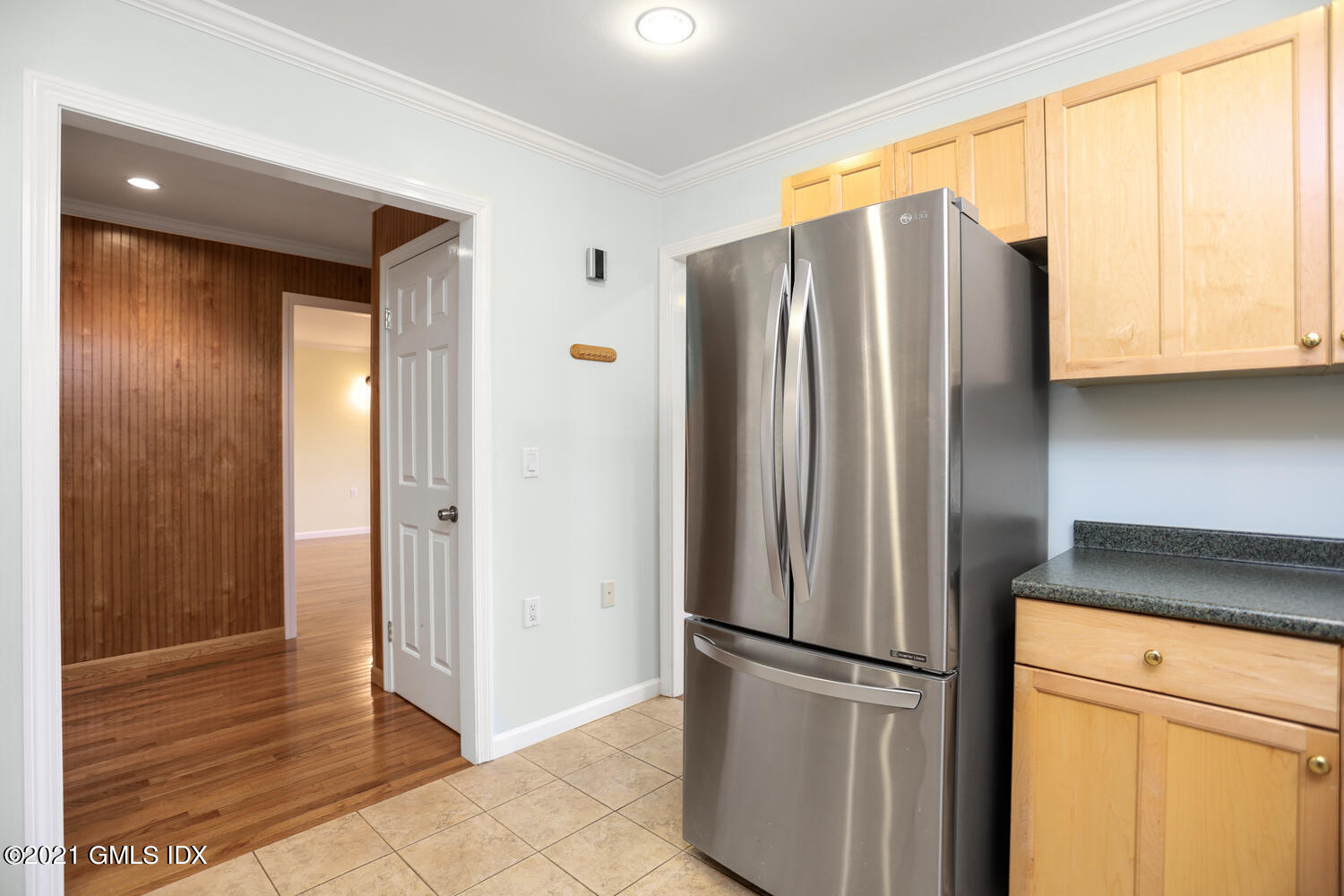 284 Glenbrook Road Stamford, CT 06906 - Photo 15 of 45 a view of a refrigerator in kitchen and an empty room with wooden floor
