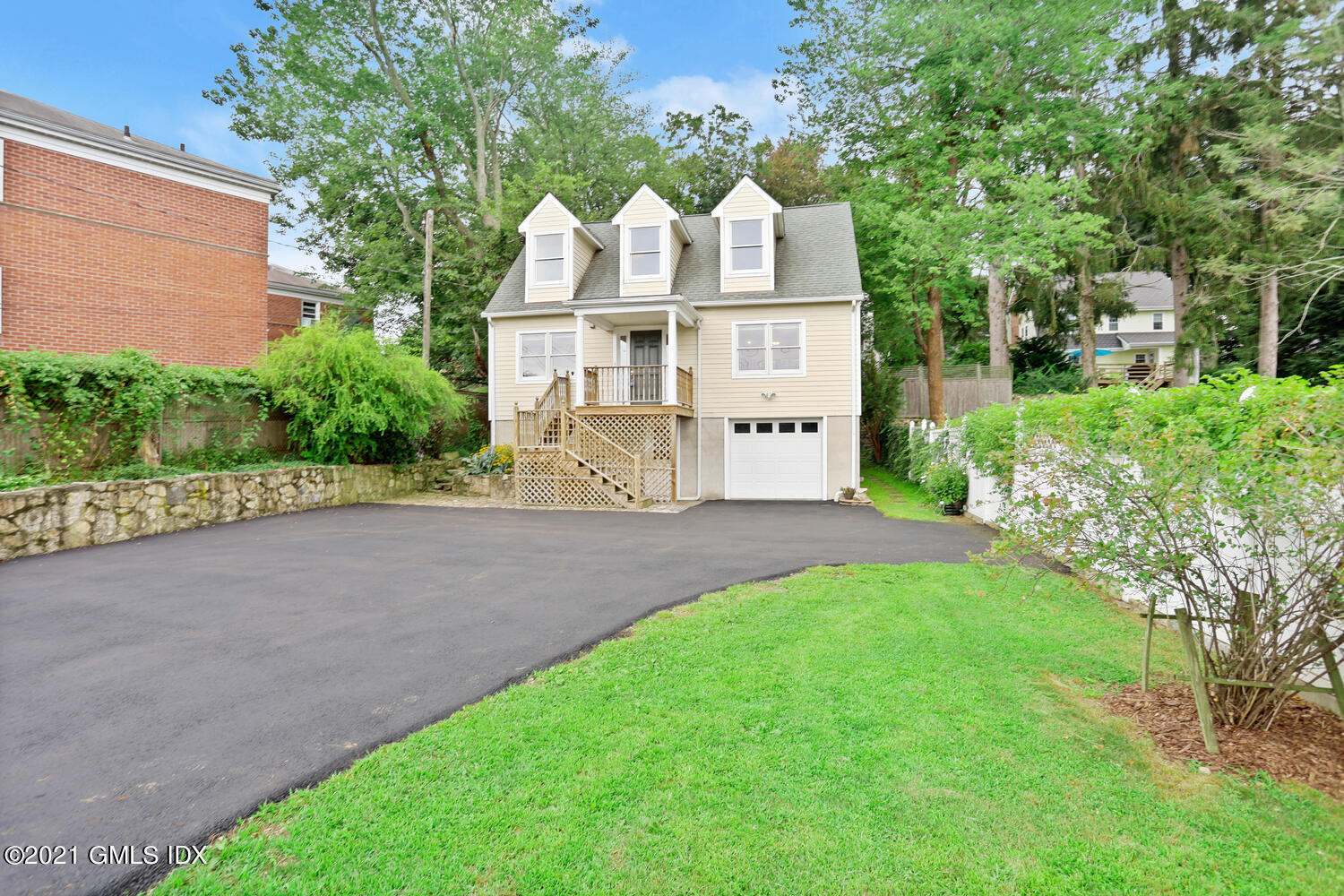 284 Glenbrook Road Stamford, CT 06906 - Photo 2 of 45 a view of a white house with a small yard and large trees