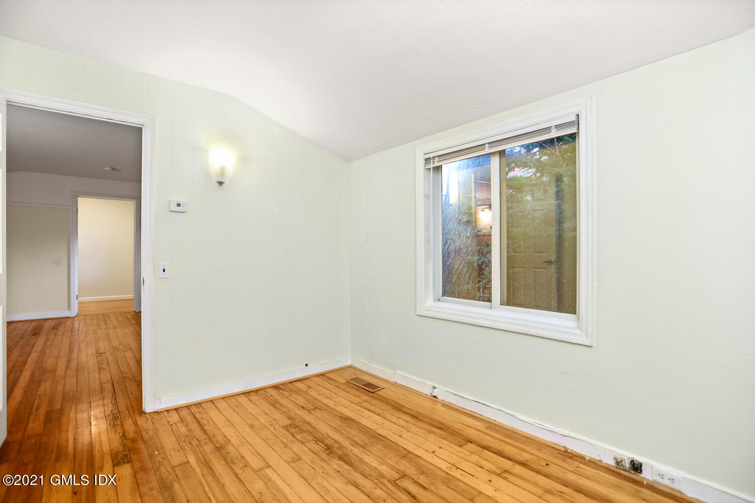 284 Glenbrook Road Stamford, CT 06906 - Photo 22 of 45 a view of an empty room with wooden floor and a window