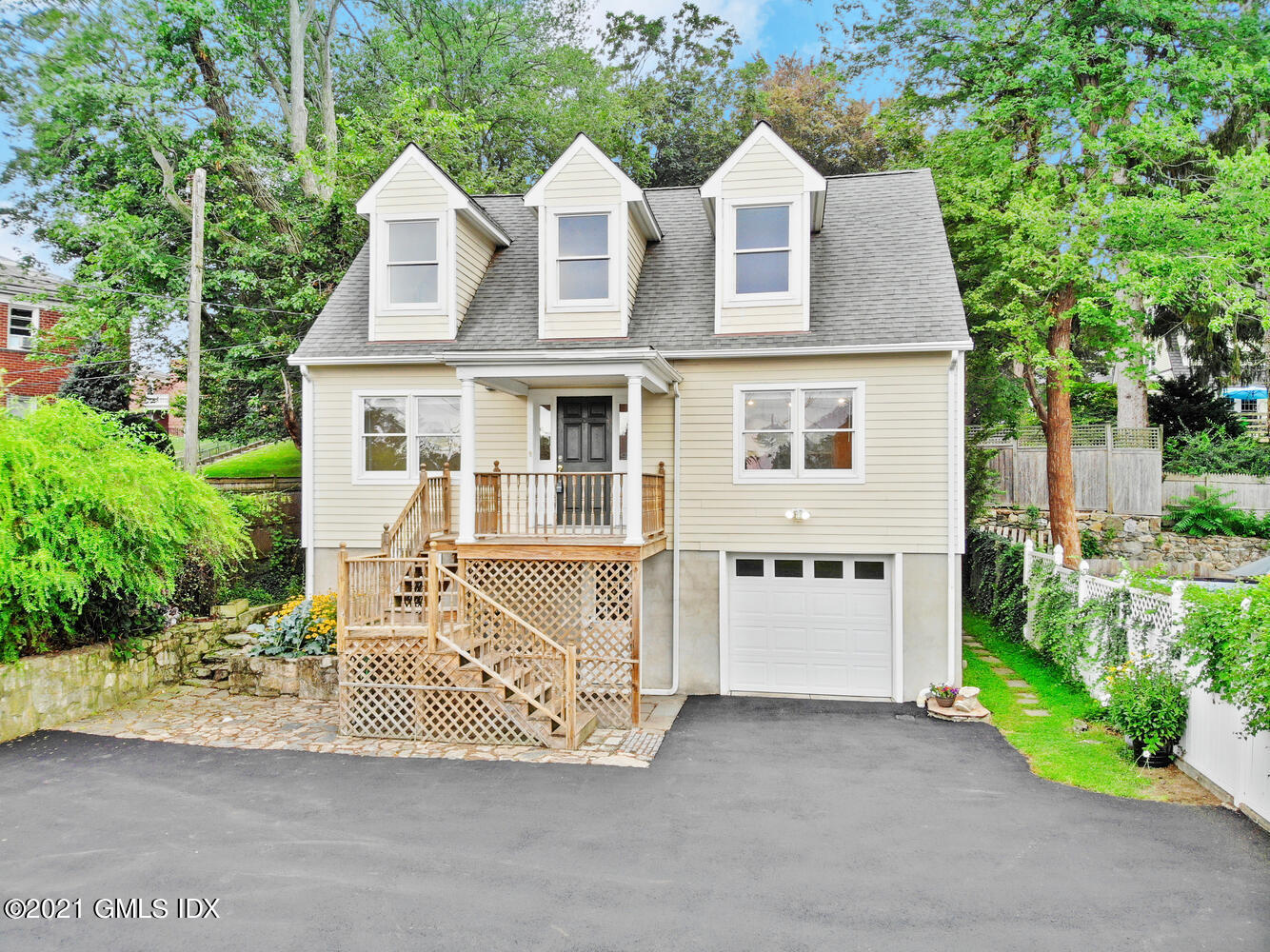 284 Glenbrook Road Stamford, CT 06906 - Photo 3 of 45 a view of a brick house with a yard plants and large tree