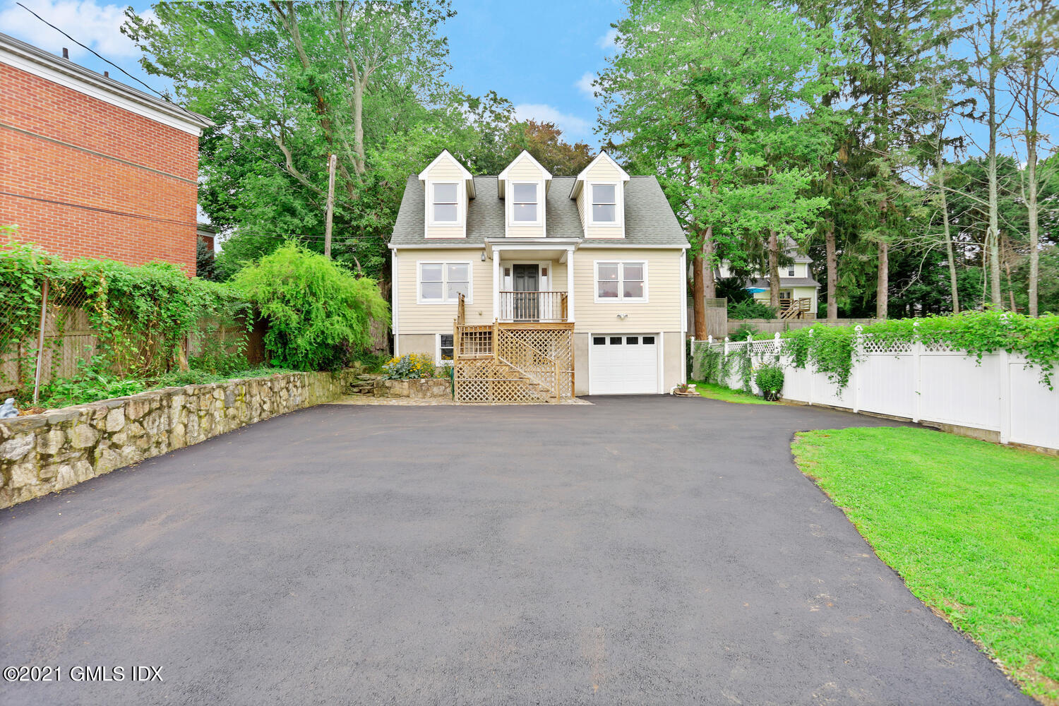 284 Glenbrook Road Stamford, CT 06906 - Photo 39 of 45 a view of a white house with a small yard and large trees