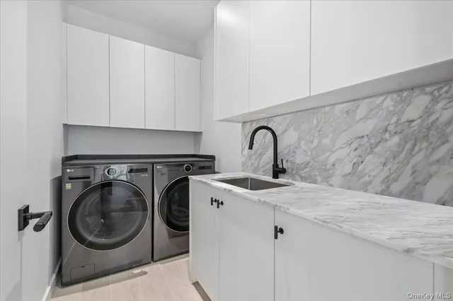 a utility room with sink dryer and washer