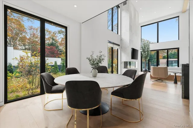 a dining room with furniture a large window and wooden floor
