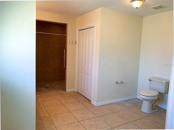 a bathroom with a granite countertop sink and a toilet