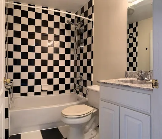 a bathroom with a granite countertop toilet a sink and a bathtub