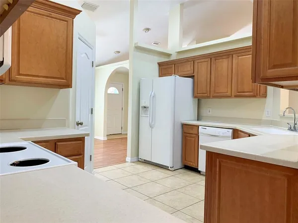 a kitchen with a refrigerator sink and cabinets