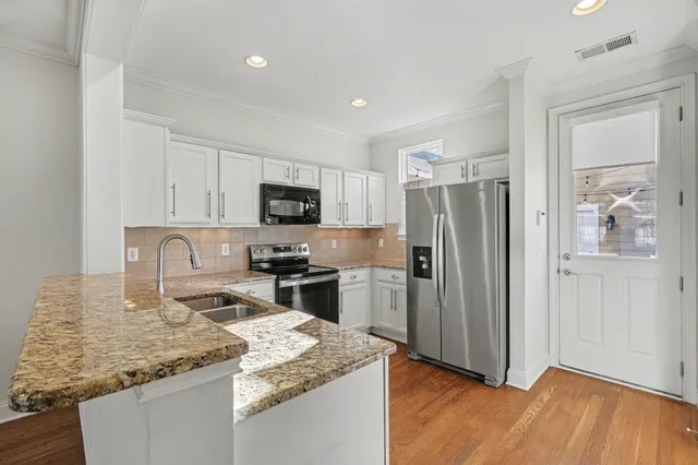 a kitchen with stainless steel appliances granite countertop a refrigerator a stove top oven a sink and dishwasher