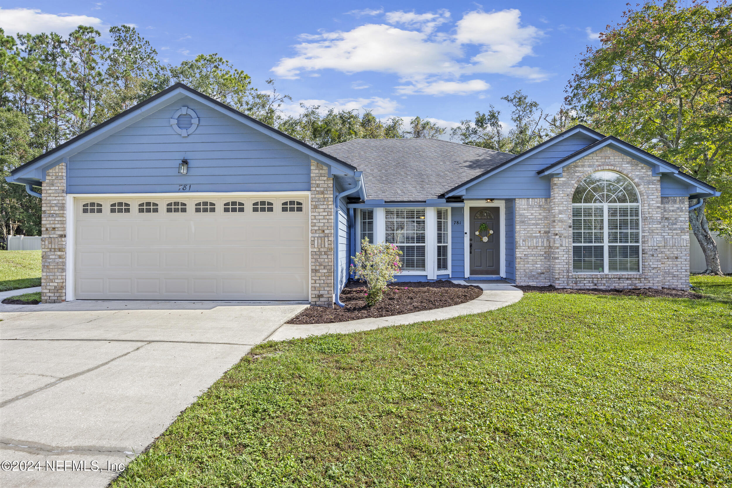 a view of a house with a yard and fence
