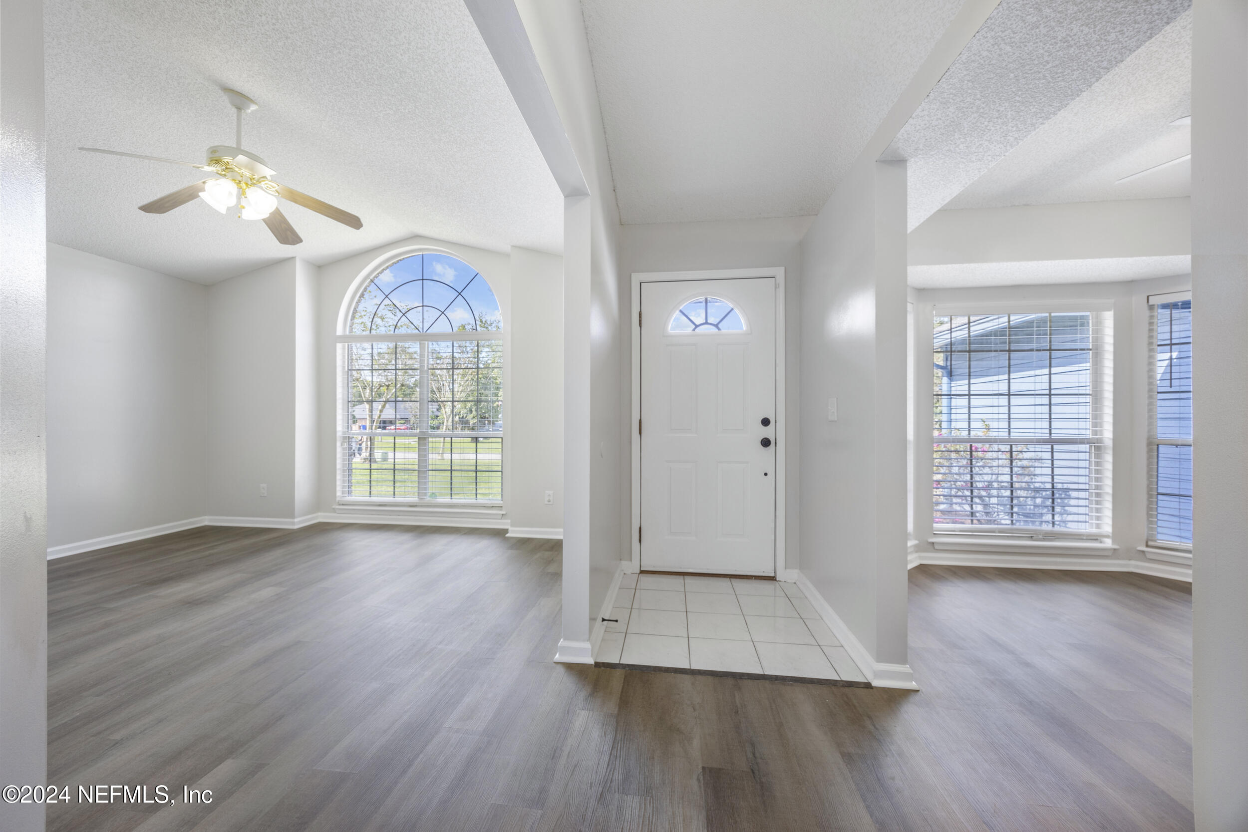 781 Nottingham Forest Circle St. Johns, FL 32259 - Photo 3 of 43 an empty room with wooden floor chandelier fan and windows
