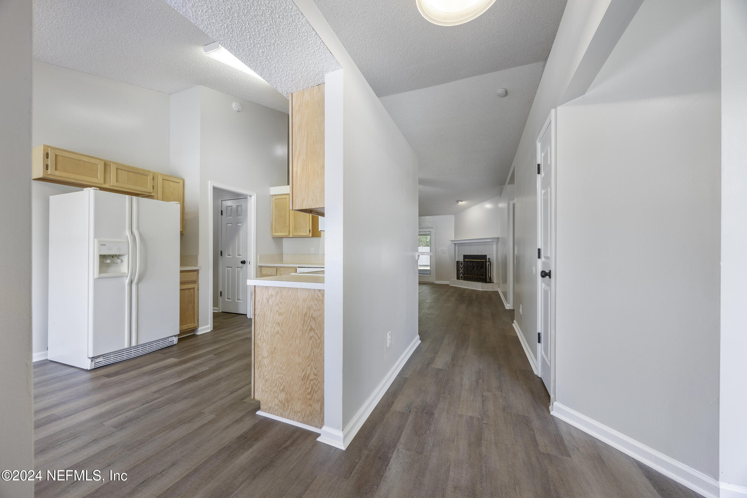 781 Nottingham Forest Circle St. Johns, FL 32259 - Photo 4 of 43 a view of a hallway with wooden floor cabinets and a kitchen