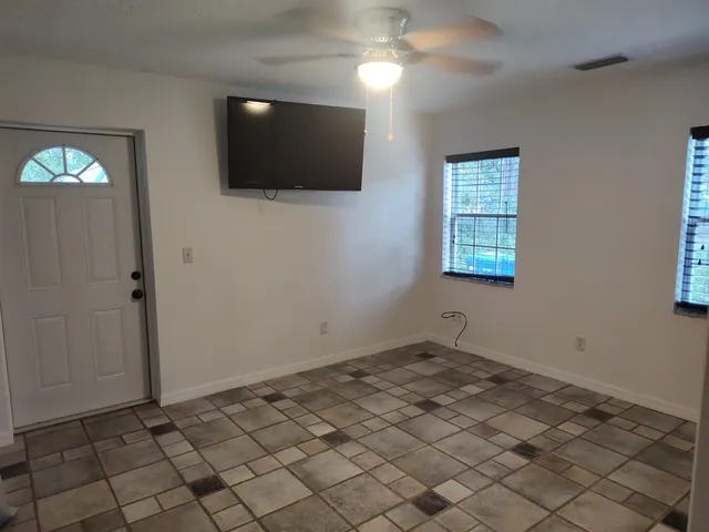 a view of a room with a white wall and a window