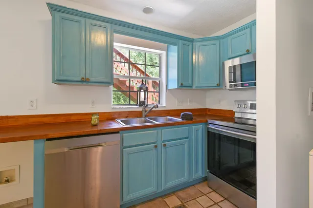 a view of kitchen with refrigerator and cabinet