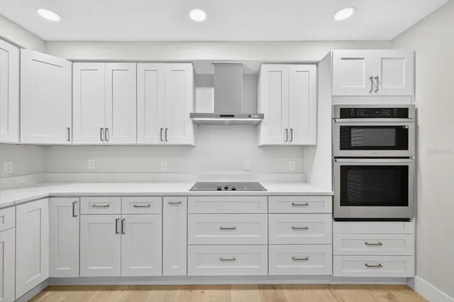 a kitchen with white cabinets and appliances